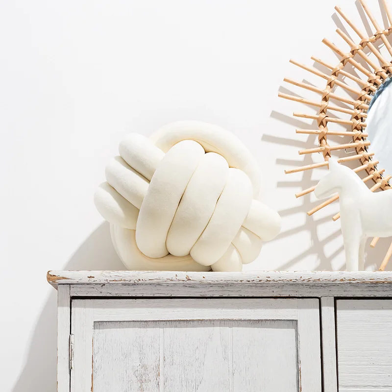 Bílý polštář ve tvaru uzlu